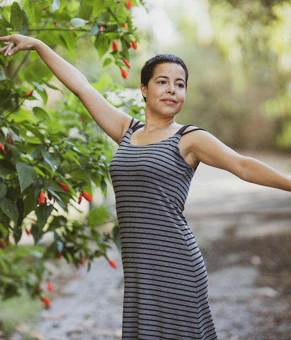 Person stretching gently outdoors with a serene expression.
